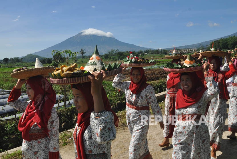 Sejumlah warga membawa nasi tumpeng dan 'ingkung' bebek menyusuri jalan desa saat tradisi Grebeg Bebek Bentisan, di Sukomarto, Jumo, Temanggung, Jawa Tengah, Ahad (3/12).