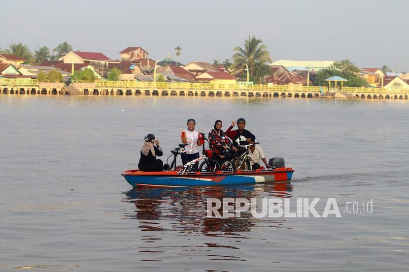 Sejumlah warga membawa sepedanya saat berkeliling menggunakan perahu di Sungai Kapuas, Pontianak, Kalimantan Barat, Kamis (15/4/2021). Sungai Kapuas menjadi salah satu tempat tujuan untuk menunggu waktu berbuka puasa (ngabuburit) bagi Muslim di Pontianak. 
