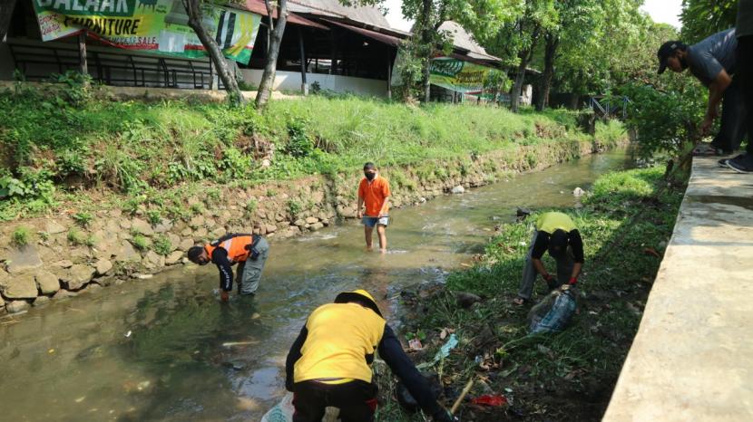 Sejumlah warga membersihkan aliran sungai Sungai Ciparigi, Kota Bogor, Ahad, (20/9). 