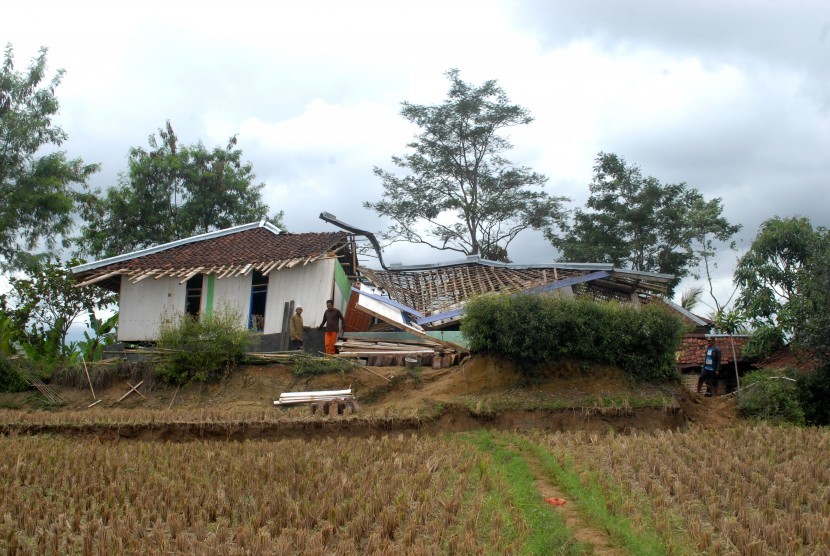 Sejumlah warga membersihkan rumah ambruk di lokasi bencana pergerakan tanah di Desa Waringinsari, Kecamatan Takokak, Cianjur, Jawa Barat, Selasa (3/10).