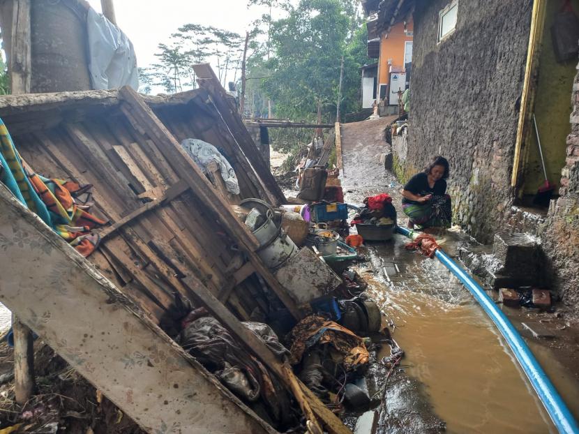 Sejumlah warga membersihkan rumah yang terdampak banjir bandang di Kampung Dayeuh Handap, Kelurahan Kota Kulon, Kecamatan Garut Kota, Kabupaten Garut, Ahad (17/7/2022). 