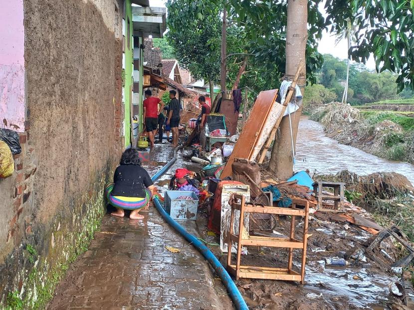 Sejumlah warga membersihkan rumah yang terdampak banjir bandang di Kampung Dayeuh Handap, Kelurahan Kota Kulon, Kecamatan Garut Kota, Kabupaten Garut, Ahad (17/7/2022). 