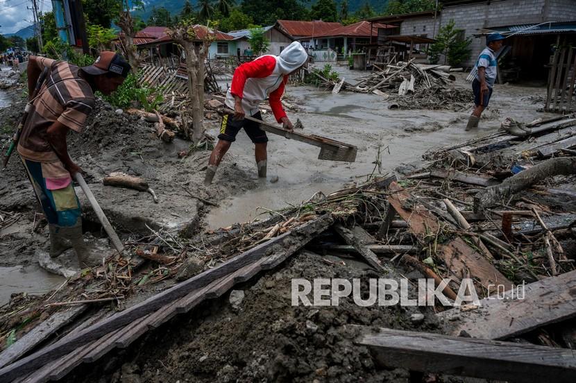 Sejumlah warga membersihkan sisa lumpur yang menerjang rumahnya di Desa Beka, Marawola, Kabupaten Sigi, Sulawesi Tengah, Sabtu (27/3/2021). Banjir lumpur yang terjadi pada Jumat (26/3) malam itu disebabkan oleh longsor pasca hujan deras di pegunungan dan menyapu pemukiman di wilayah tersebut dan mengakibatkan 70 rumah warga rusak berat, lebih dari 100 unit rumah rusak ringan dan sebanyak 200 warga terpaksa diungsikan.