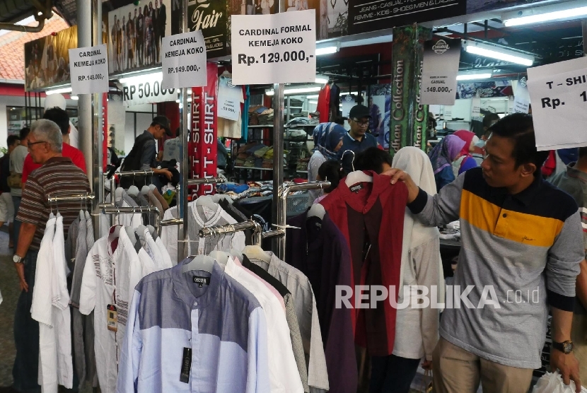  Sejumlah warga memilih berbagai baju yang didiskon di area Pekan Raya Jakarta (PRJ), Selasa (13/6). 