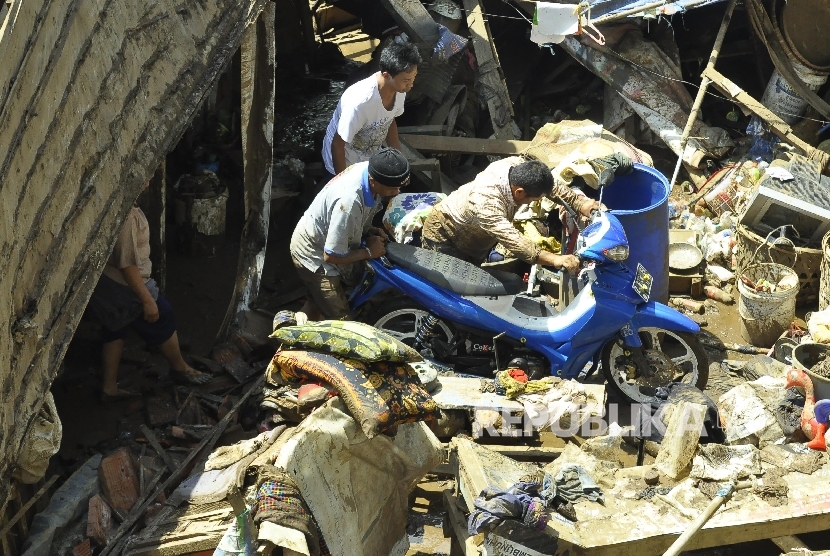   Sejumlah warga memindahkan kendaraan motor pasca banjir bandang di Tarogong Kidul, Kabupaten Garut, Kamis (22/9).