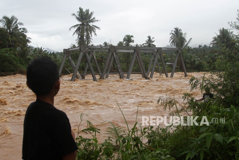 Sejumlah warga memperhatikan jembatan yang terbawa arus di Kelurahan Baringin, Lubuk Kilangan, Padang, Sumatera Barat, Jumat (2/11/2018).