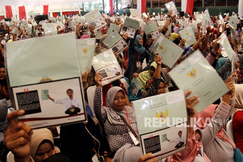 Sejumlah warga memperlihatkan sertifikat tanah usai dibagikan saat Penyerahan Sertifikat Tanah Untuk Rakyat di Makassar, Sulawesi Selatan, Kamis (28/12).