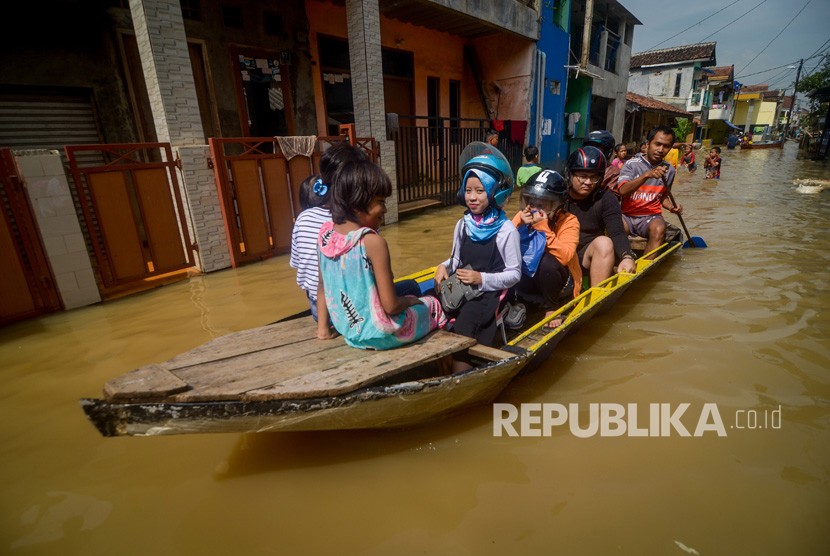 Sejumlah warga menaiki perahu melintasi banjir di Bojongasih, Dayeuhkolot, Kabupaten Bandung, Jawa Barat. 