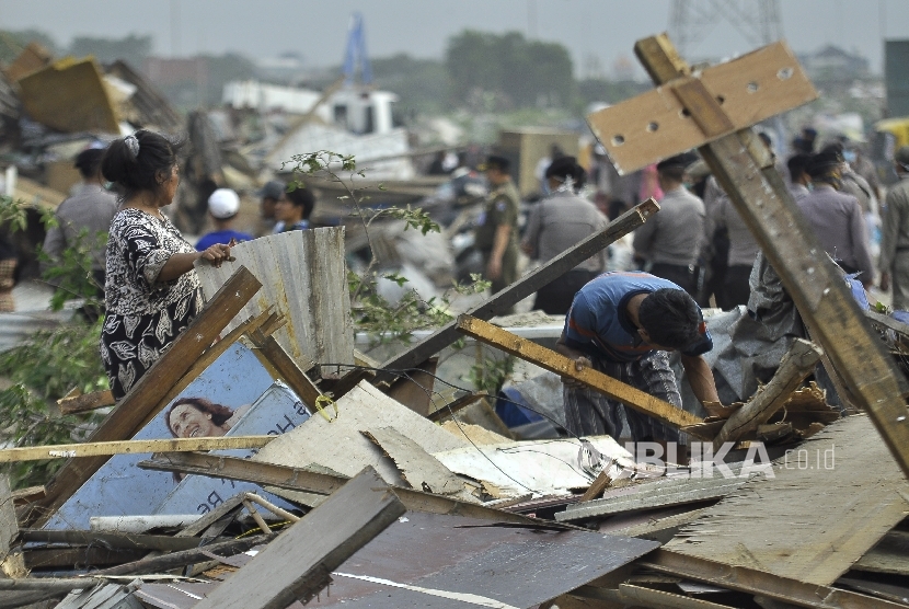 Sejumlah warga mencari barang-barang pribadinya saat petugas membongkar bangunan liar di Kawasan Taman Bersih, Manusiawi dan Berwibawa (BMW), Kecamatan Tanjung Priok, Jakarta, Selasa (1/8).