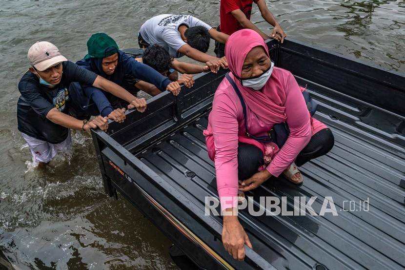 Sejumlah warga mendorong mobil mogok akibat menembus jalur Pantura akibat banjir menerjang Kota Semarang, Jateng.
