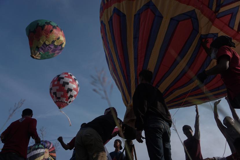 Sejumlah warga menerbangkan balon udara yang ditambatkan di tanah saat Balloon Attraction Pekalongan 2022 di Lapangan Mataram, Kota Pekalongan, Jawa Tengah, Ahad (8/5/2022). ara.