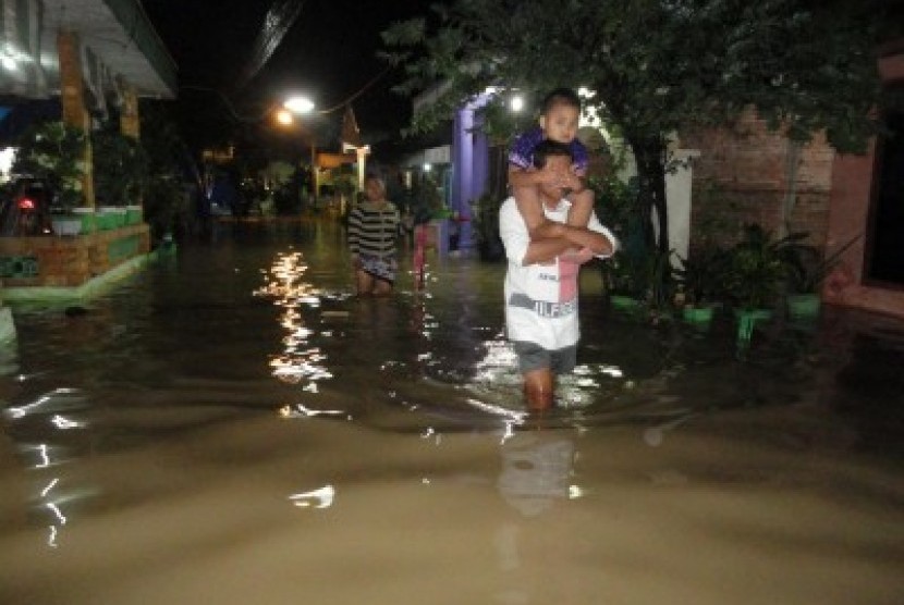 Sejumlah warga menerobos genangan banjir akibat luapan Sungai Bengawan Solo di Desa Ledokwetan, Kecamatan Kota, Bojonegoro, Jatim.