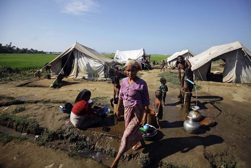 Sejumlah warga mengambil air di sebuah kamp pengungsi bagi warga muslim yang terlantar akibat aksi kekerasan awal tahun ini di luar Sittwe, Myanmar,  Selasa (30/10).   (Soe Zeya Tun/Reuters)