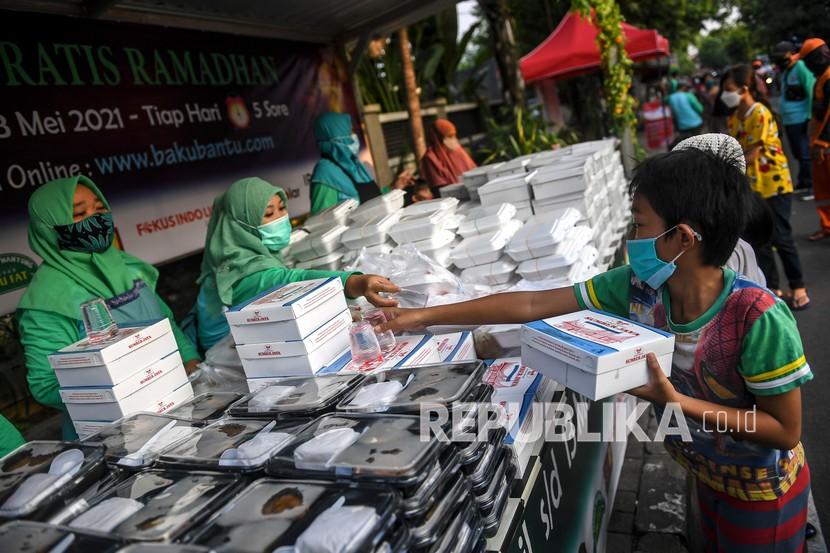 Sejumlah warga mengantre dengan menerapkan protokol kesehatan saat mengambil makanan berbuka puasa gratis di Jalan Cempaka Putih Tengah, Jakarta, Jumat (16/4/2021). Sekitar 400-600 paket takjil yang merupakan donasi dari warga dan perusahaan sekitar dibagikan secara gratis selama bulan Ramadhan tahun ini.