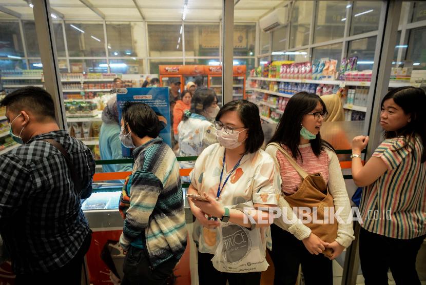 Sejumlah warga mengantre membeli masker saat operasi pasar masker di JakMart, Pasar Pramuka, Jumat (6/3).