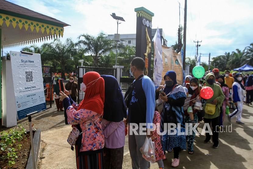 Sejumlah warga mengantre untuk masuk di Alun-Alun Kota Depok, Depok, Jawa Barat, Ahad (26/12/2021). Pemerintah Kota Depok kembali membuka alun-alun dengan menerapkan protokol kesehatan dan pembatasan pengunjung setelah kasus COVID-19 menurun dan berada pada PPKM level 1. 
