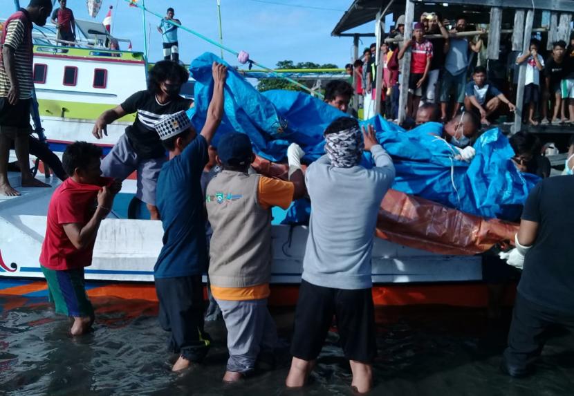 Sejumlah warga mengevakuasi korban meninggal dunia tenggelamnya KM Ladang Pertiwi Dua yang ditemukan nelayan di Pulau Pamantauang, Kabupaten Pangkep, Sulawesi Selatan, Rabu (1/6/2022). Badan Nasional Pencarian dan Pertolongan (Basarnas) Sulawesi Selatan menyatakan, dua jenazah korban KM Ladang Pertiwi 2 yang tenggelam di perairan Selat Makassar kembali ditemukan pada hari ini, Kamis (2/6/2022).