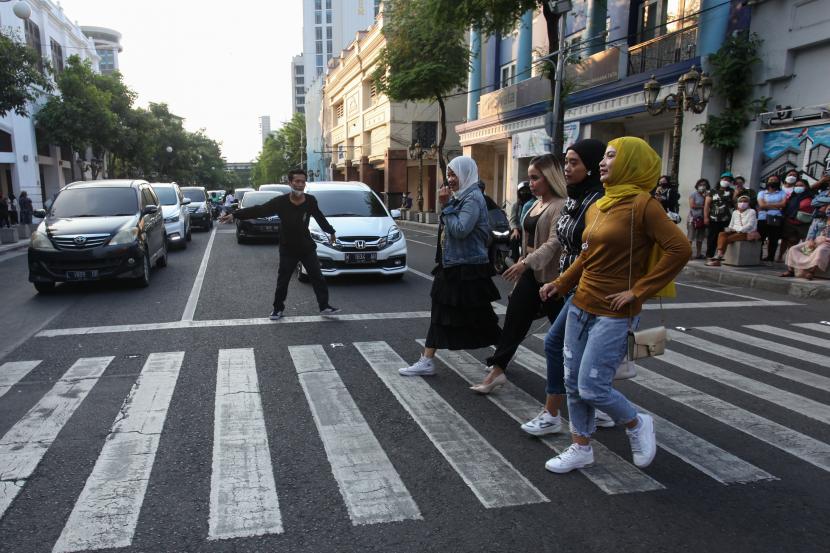 Sejumlah warga menggelar peragaan busana di tempat penyeberangan atau zebra cross di jalan Tunjungan, Kota Surabaya, Jawa Timur, Ahad (24/7/2022).