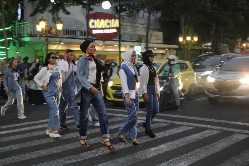 Sejumlah warga menggelar peragaan busana di tempat penyeberangan atau zebra cross di jalan Tunjungan, Surabaya, Jawa Timur,  Ahad (24/7/2022). Aksi fashion on the street itu untuk meramaikan kawasan wisata Heritage Tunjungan Romansa yang ramai wisatawan. 