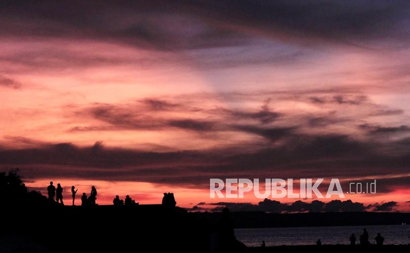 Sejumlah warga menikmati suasana matahari terbenam atau sunset di pesisir Pantai Lai-Lai Besi Kopan (LLBK) di Kota Kupang, NTT Ahad (3/4/2022). Perbedaan Hemat dan Pelit Menurut Ulama