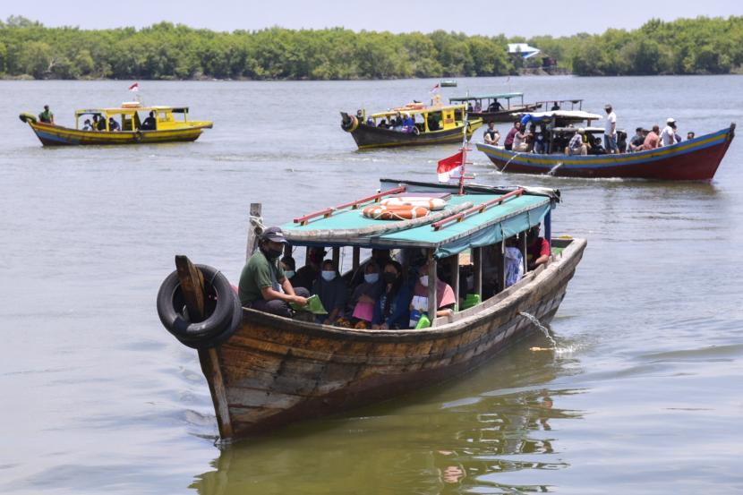 Sejumlah warga menumpang perahu tradisional saat hendak mengikuti serbuan vaksin kepada masyarakat maritim di Dermaga Mako Lantamal I Belawan, Kota Medan, Sumatera Utara, Senin (30/8/2021). TNI Angkatan Laut menggelar serbuan vaksin COVID-19 untuk masyarakat maritim guna mewujudkan kekebalan komunal atau 