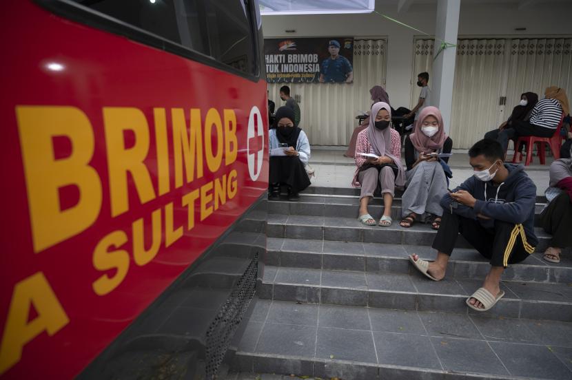 Sejumlah warga menunggu giliran mendapatkan vaksinasi COVID-19 yang digelar Brimobda Sulteng di sebuah kawasan wisata di Palu, Sulawesi Tengah, Sabtu (18/12/2021). Capaian vaksinasi COVID-19 di Sulawesi Tengah saat ini untuk dosis I mencapai 55 persen dan dosis II sebesar 31,5 persen sehingga Satuan Brimob Polda Sulteng menyisir dan membuka gerai vaksinasi di sejumlah kawasan wisata untuk mengejar target vaksinasi khusus dosis I sebesar 60 persen hingga akhir tahun 2021. PPKM Level 3 di Sulteng Diperpanjang Hingga 14 Maret 2022