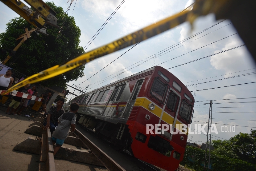 Sejumlah warga menunggu laju kereta api untuk menyeberang di pintu perlintasan (Ilustras)