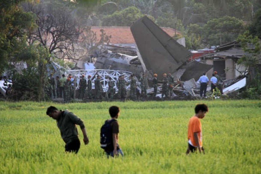  Sejumlah warga menyaksikan bangkai pesawat Fokker 27 yang terjatuh di komplek Rajawali, Lapangan Udara Halim Perdana Kusuma, Jakarta, Kamis (21/6). 