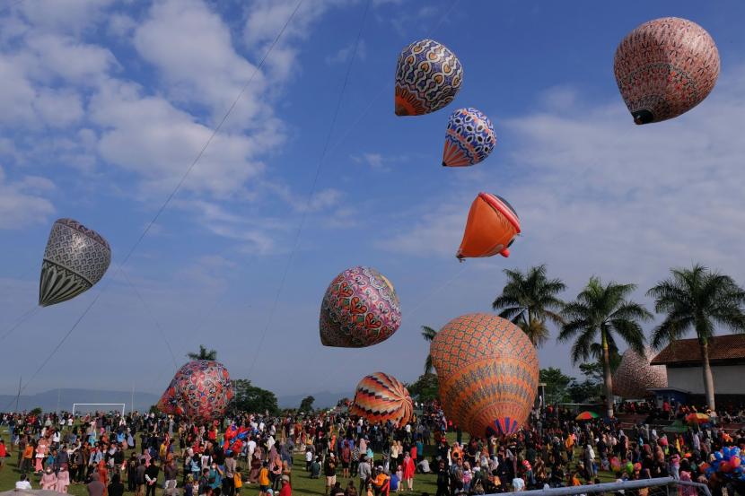 Sejumlah warga menyaksikan penerbangan balon udara di lapangan desa Kembaran, Kalikajar, Wonosobo, Jateng, Rabu (19/5/2021). Tradisi penerbangan balon udara tradisional rutin dilaksanakan masyarakat setempat pada hari ke tujuh Lebaran, agar tidak mengganggu lalu lintas udara balon udara ditambatkan menggunakan tali dengan ketinggian tertentu.