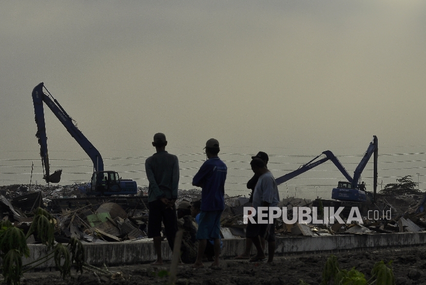 Sejumlah warga menyaksikan saat petugas membongkar bangunan liar di Kawasan Taman Bersih, Manusiawi dan Berwibawa (BMW), Kecamatan Tanjung Priok, Jakarta, Selasa (1/8).