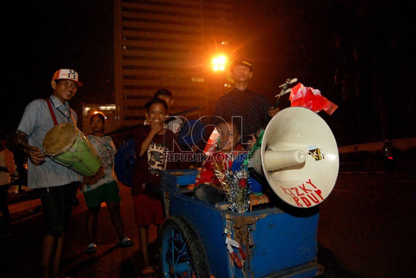  Sejumlah warga menyambut hari lebaran dengan takbir keliling menggunakan gerobak di Jalan M.H Thamrin, Jakarta Pusat, Ahad (27/7).  (Republika/Raisan Al Farisi)