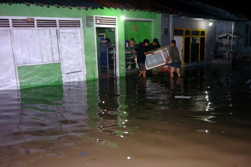 Sejumlah warga menyelamatkan barang-barang saat rumahnya tergenang banjir. Ilustrasi