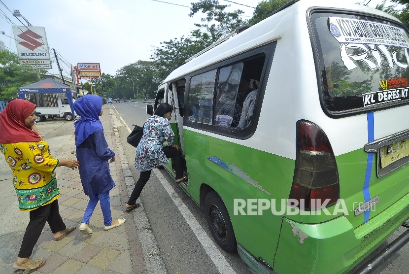  Sejumlah warga naiki kendaraan angkutan kota (angkot) di ruas Jalan Daan Mogot, Tangerang, Rabu (5/7). 