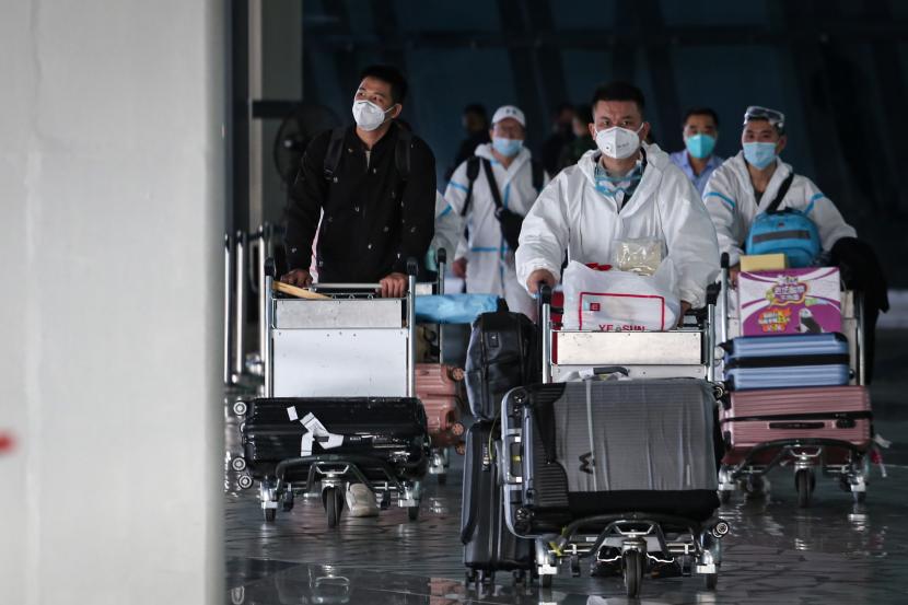 Sejumlah warga negara asing (WNA) dengan menggunakan baju hazmat tiba di Bandara Internasional Soekarno Hatta, Tangerang, Banten.