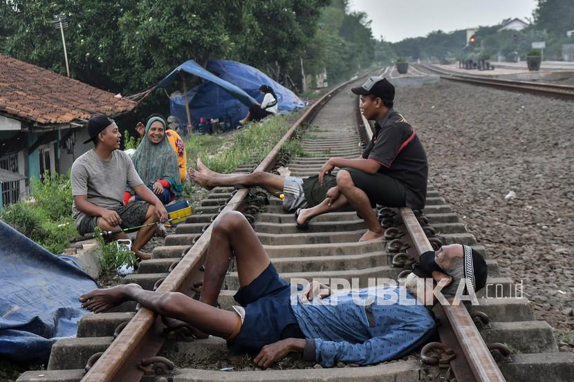 Sejumlah warga beristirahat di lintasan rel kereta (ilustrasi).