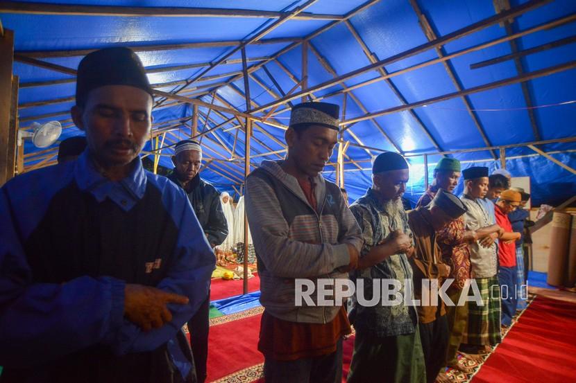 Sejumlah warga penyintas gempa melaksanakan shalat Tarawih di mushala darurat Jorong Tanjung Beruang, Nagari Kajai, Kabupaten Pasaman Barat, Sumatera Barat, Rabu (6/4/2022). Sebagian warga penyintas gempa terpaksa melaksanakan shalat Tarawih di tenda darurat, karena mushala dan masjid rusak akibat gempa. Masjid Al-Mukhlisin yang Hancur Akibat Gempa Pasaman Kembali Dibangun