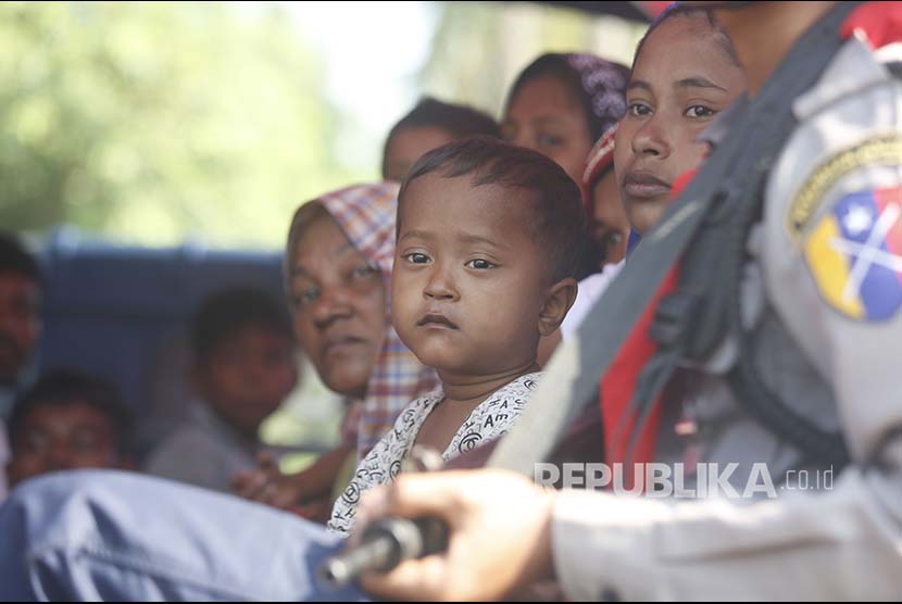 Sejumlah warga Rohingya menunggu di truk Polisi Myanmar untuk dibawa kembali menuju penampungan sementara yang didirika pemerintah di Desa ManSi dekat Sittwe, Negara Bagian Rakhinne, Myanmar, Rabu (21/11). 