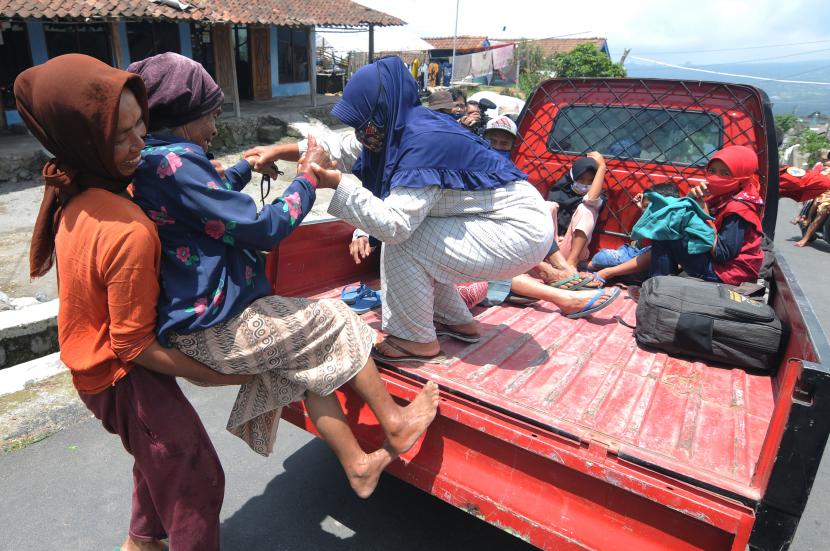 Sejumlah warga saling membantu saat proses evakuasi lansia di Stabelan, Tlogolele, Selo, Boyolali, Jawa Tengah, Senin (9/11/2020). Proses evakuasi dilakukan bagi warga lansia, ibu hamil dan anak-anak yang tinggal di Kawasan Rawan Bencana (KRB) III desa Tlogolele yaitu dukuh Stabelan, Takeran dan Mbelang.