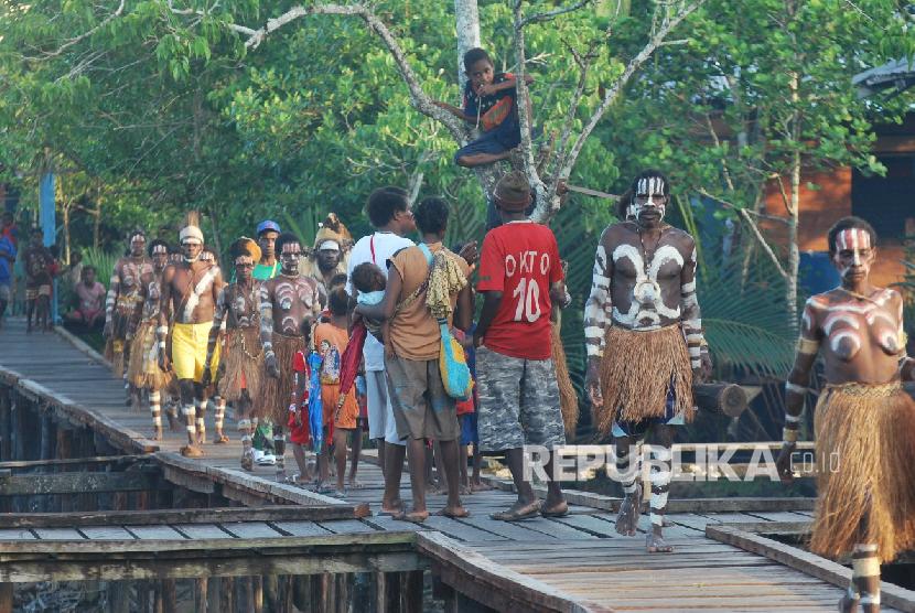 Sejumlah warga Suku Asmat berjalan disebuah perempatan jalan yang terbuat dari papan di Kabupaten Asmat Propinsi Papua
