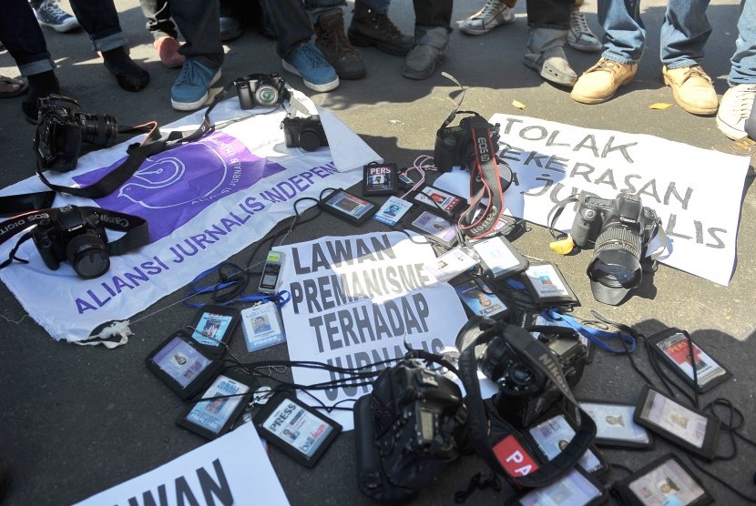 Sejumlah wartawan meletakkan kartu pers dan peralatan liputan sebagai bentuk protes terhadap aksi kekerasan terhadap jurnalis saat unjuk rasa di depan Monumen Bajra Sandhi, Denpasar, Selasa (7/7). 