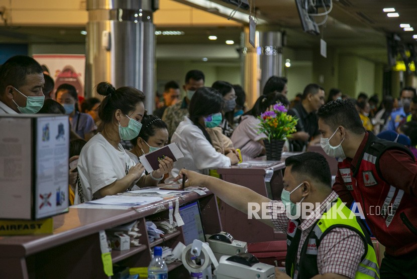 Sejumlah wisatawan asing asal China antre di konter lapor diri (check-in) Terminal Keberangkatan Bandara Hang Nadim, Batam, Kepulauan Riau, Selasa (28/1/2020). Virus corona menyebabkan sejumlah daerah wisata di Indonesia terimbas dengan minimnya turis China.