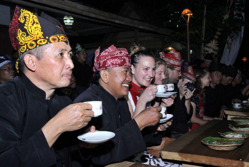 Sejumlah wisatawan asing menikmati kopi gratis saat menghadiri Festival Ngopi Sepuluhewu (Sepuluh ribu Kopi) di Kemiren, Banyuwangi, Jawa Timur, Sabtu (5/11). 