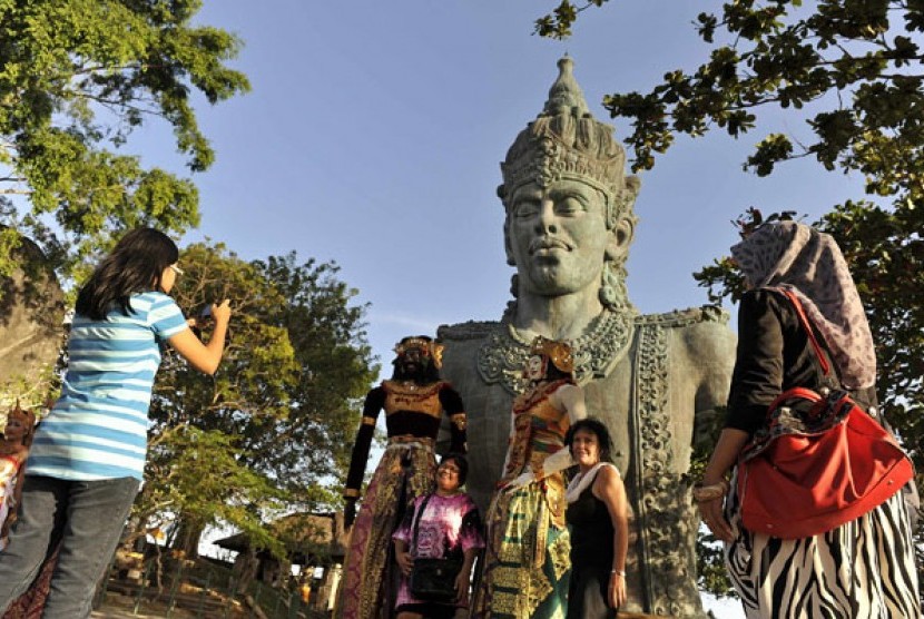 Sejumlah wisatawan berfoto di depan potongan patung Wisnu yaitu bagian dari patung Garuda Wisnu Kencana (GWK), Badung, Bali, Kamis (22/8). 