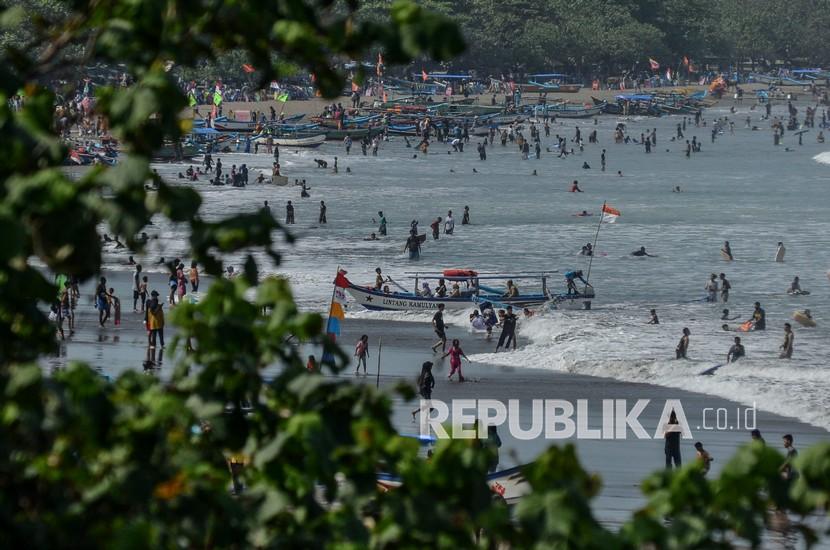 Sejumlah wisatawan bermain air di Pesisir Pantai, Kabupaten Pangandaran, Jawa Barat, Senin (17/5/2022). Kasus Covid-19 di Pangandaran tetap landai usai liburan panjang lebaran.