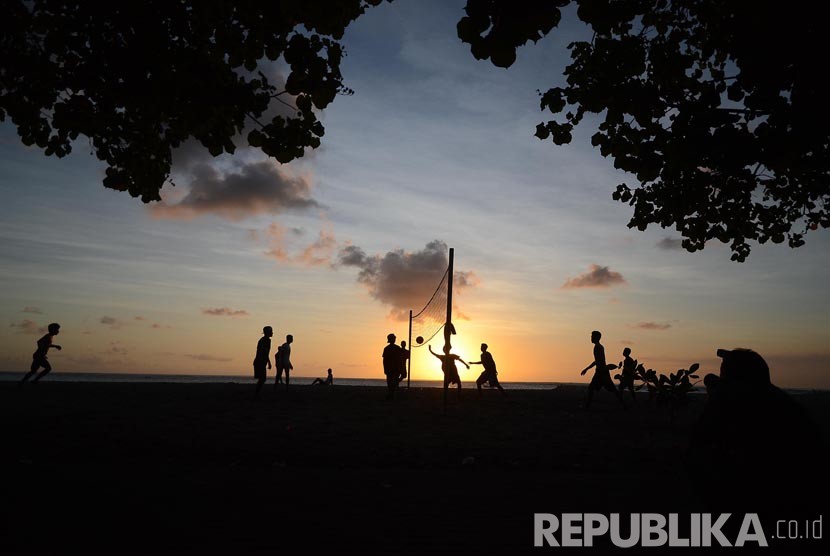 Sejumlah wisatawan bermain volly saat sunset di pantai Kuta yang merupakan area kawasan  hotel Patra Jasa, Bali, Rabu (18/5). (Republika/Musiron) 