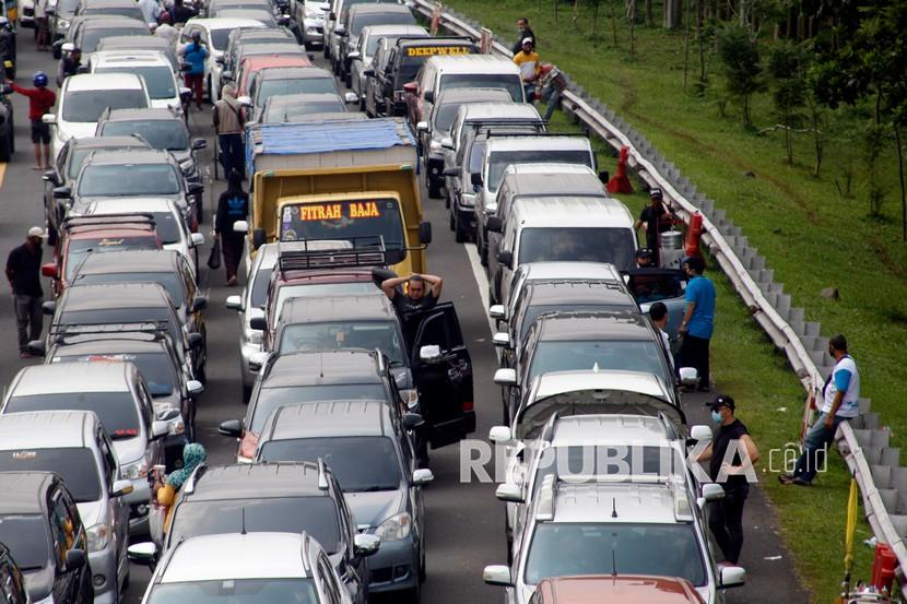 Sejumlah wisatawan keluar dari kendaraannya menunggu kemacetan reda akibat buka tutup jalan Puncak, Gadog, Kabupaten Bogor, Jawa Barat.