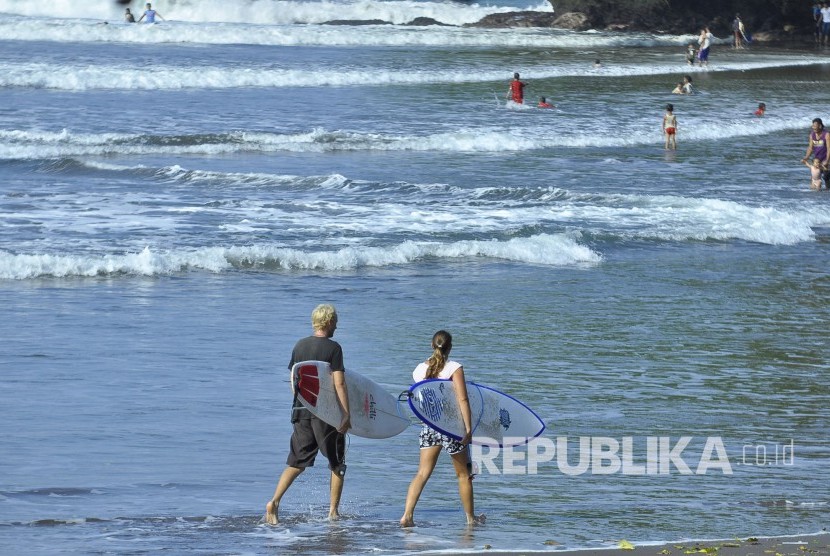 Sejumlah wisatawan mancanegara berjalan dengan membawa papan surfing di Pantai Batukaras, Kabupaten Pangandaran, Jawa Barat, Rabu (17/8). (Mahmud Muhyidin)
