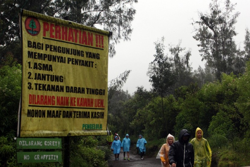 Sejumlah wisatawan menggunakan jas hujan saat mendaki di Gunung Ijen, Banyuwangi, Jawa Timur, Rabu (27/7). 