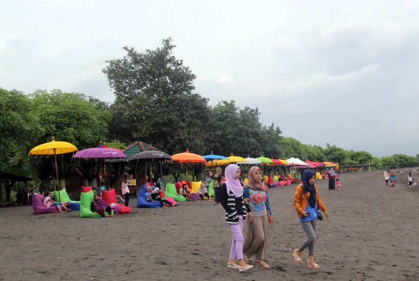 Sejumlah wisatawan menikmati suasana pantai khusus wanita di Banyuwangi, Jawa Timur, Minggu (26/3). 