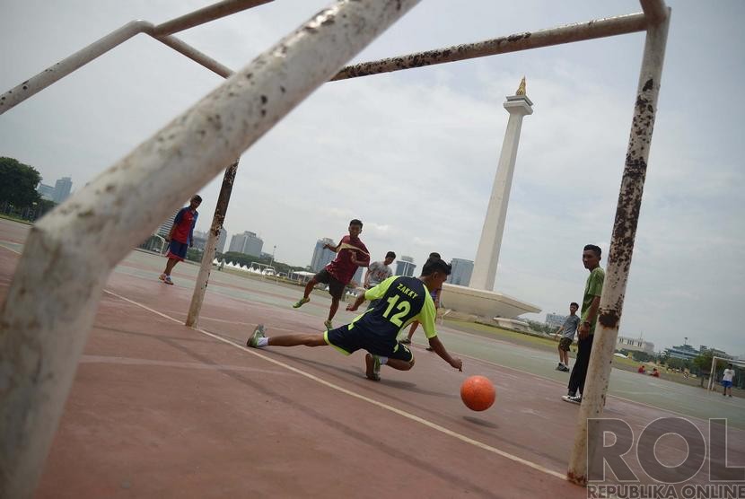 Sekelompok anak bermain futsal di lapangan pelataran Monumen Nasional (Monas), Ahad, (7/12).  (Republika/Raisan Al Farisi)